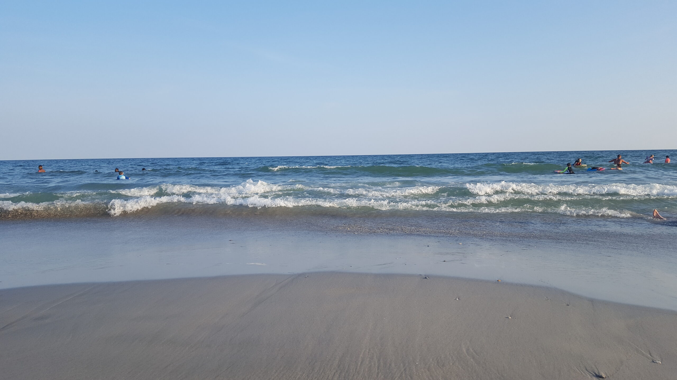 A beautiful photo of the ocean waves coming to shore on a serene beach in the Carolinas