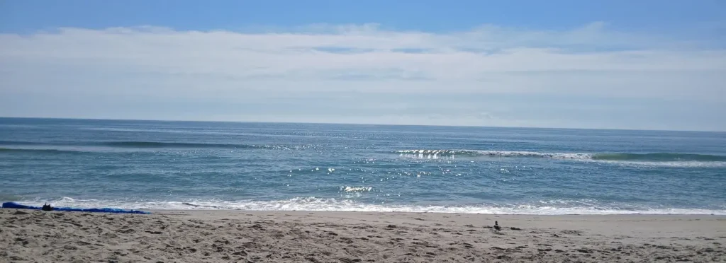 waves crashing into the beach on a sunny day