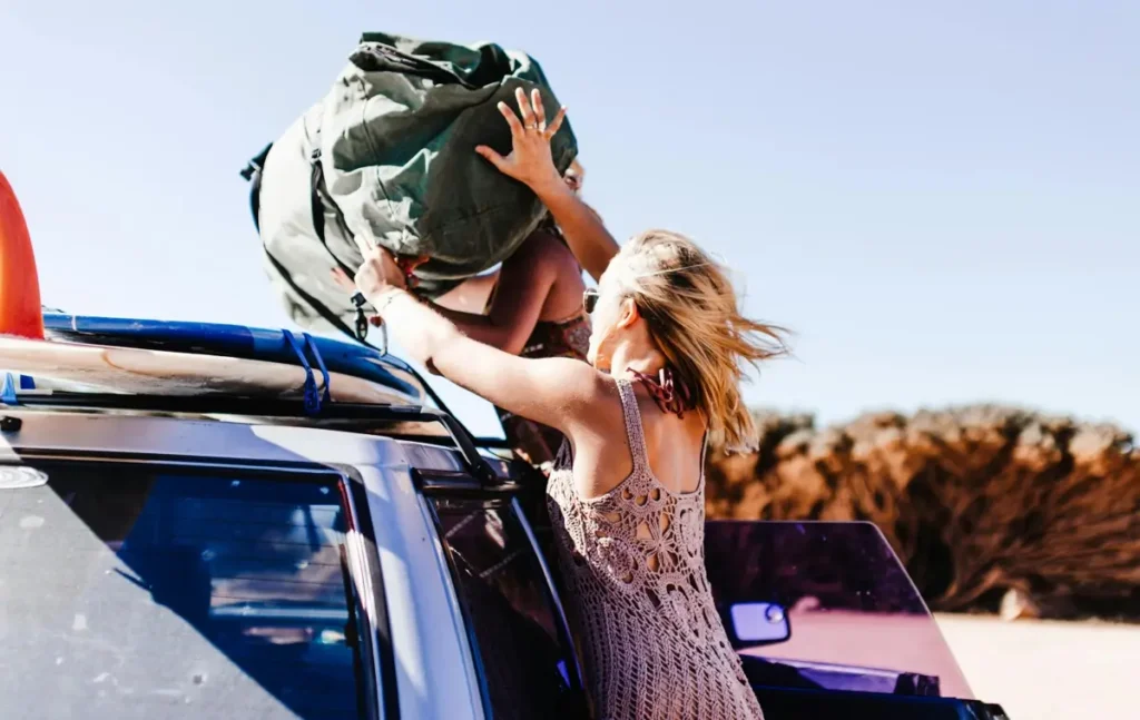 packing bags on top of a car for a beach trip