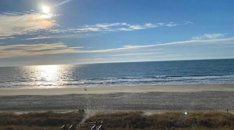 sunrise over the ocean as waves crash into the sandy beach at Cherry Grove in South Carolina