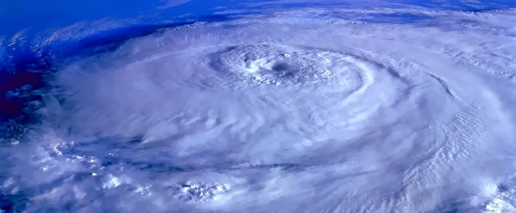 Satellite view of a powerful hurricane with a clear, well-defined eye spinning over the deep blue ocean.