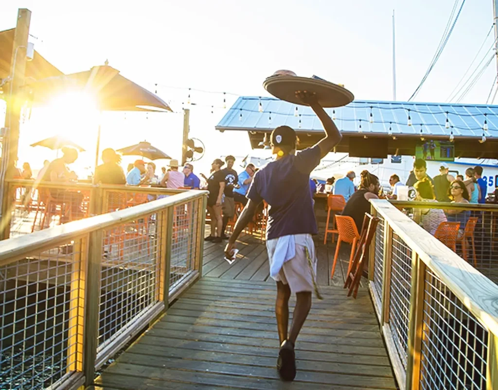 Server walking the waterfront docks at sunset at Hudson's Seafood House, Hilton Head