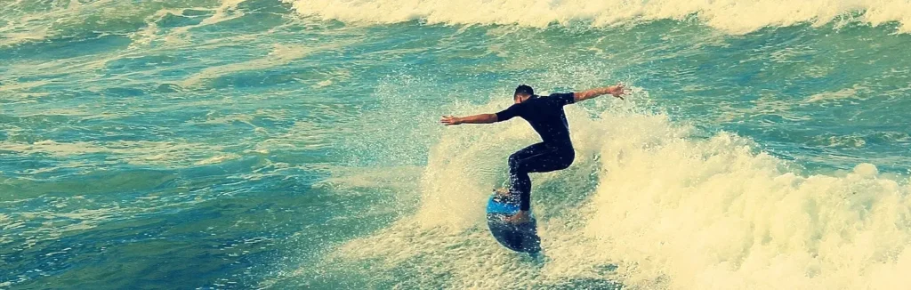 Surfer carving a turn on a wave in a wetsuit