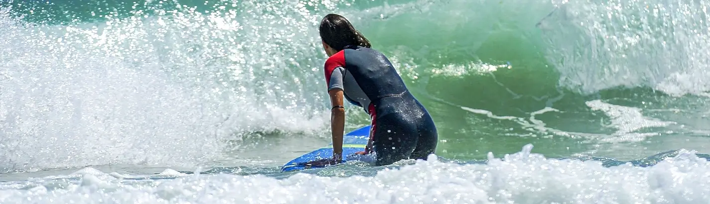 Surfer paddling through breaking whitewater in a wetsuit