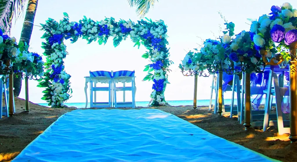 Blue floral wedding arch with aisle runner on a beach ceremony site