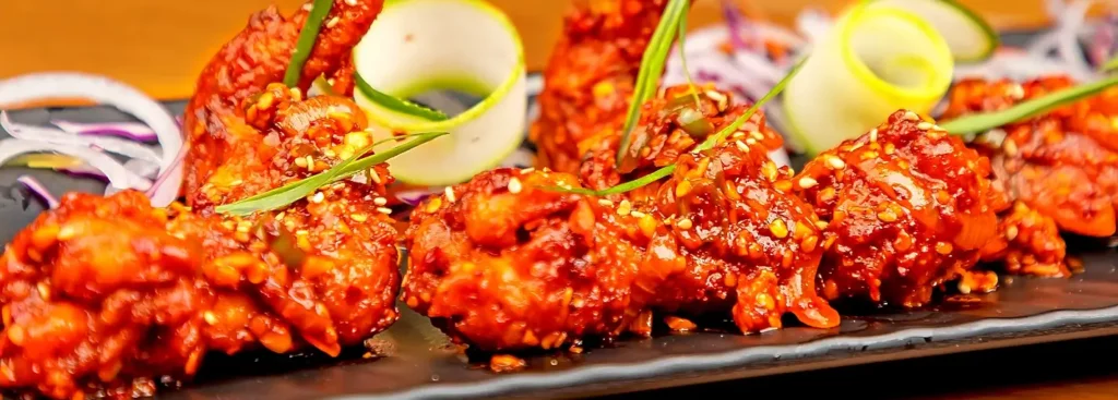 Buffalo-style chicken wings garnished with scallions and citrus zest, served with ranch dip