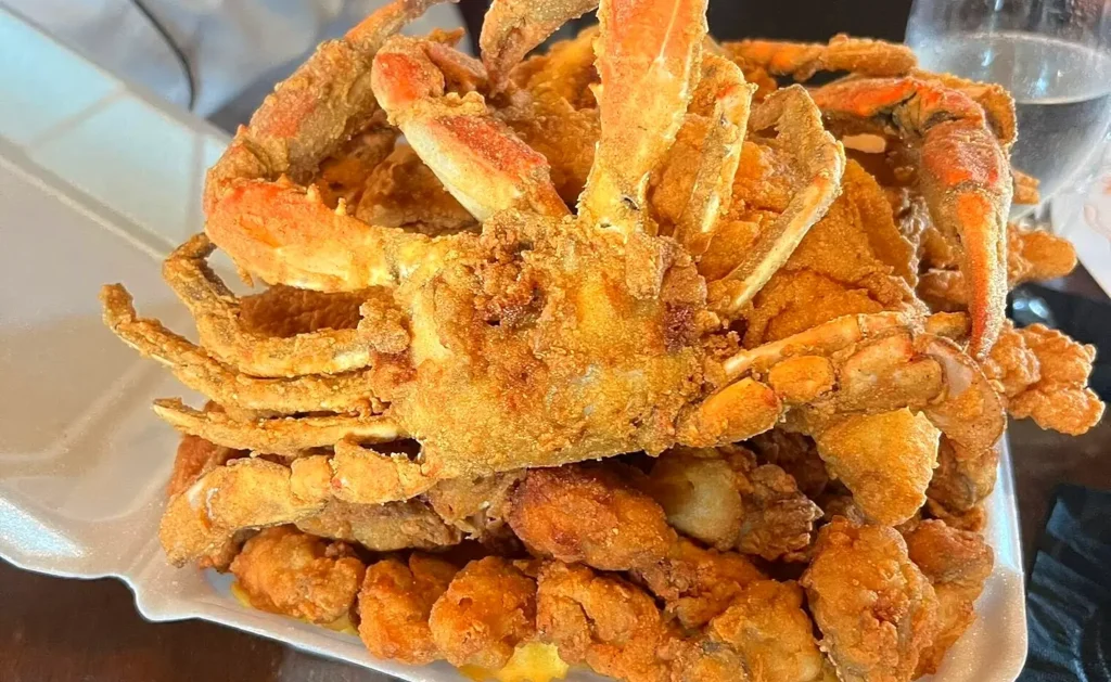 A festival plate piled with fried soft shell crab and golden fried shrimp