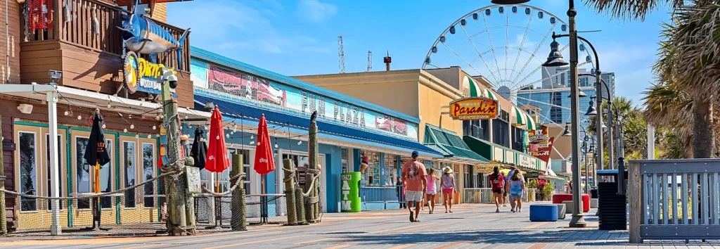 Myrtle Beach Boardwalk with shops, the SkyWheel, and beachgoers