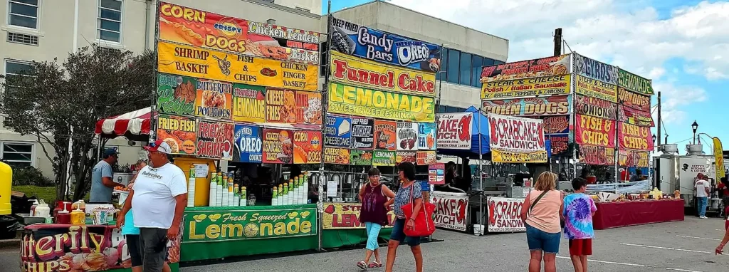 Carnival food stand signage for funnel cake, corn dogs, and crab cake sandwiches