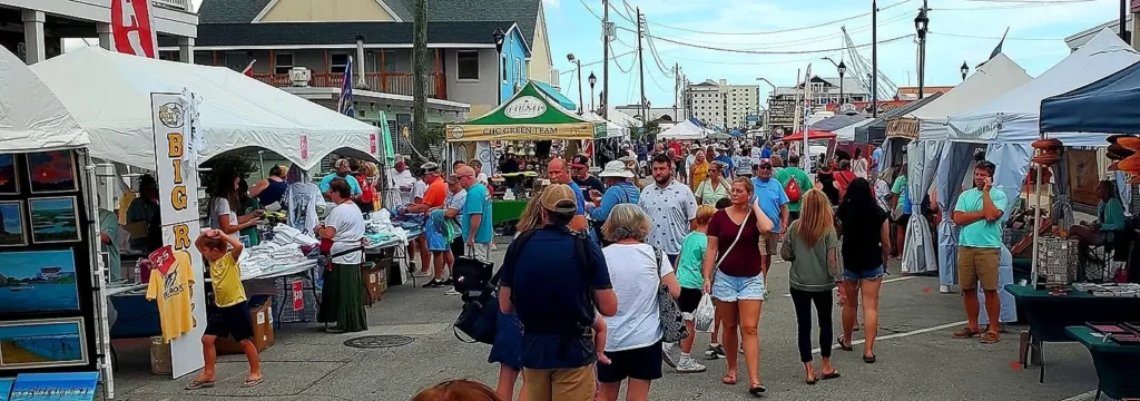 Crowd browsing craft vendor tents on Morehead City's festival waterfront street