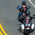 Three motorcycles cruising down a road during Myrtle Beach Bike Week, riders wearing leather jackets and helmets