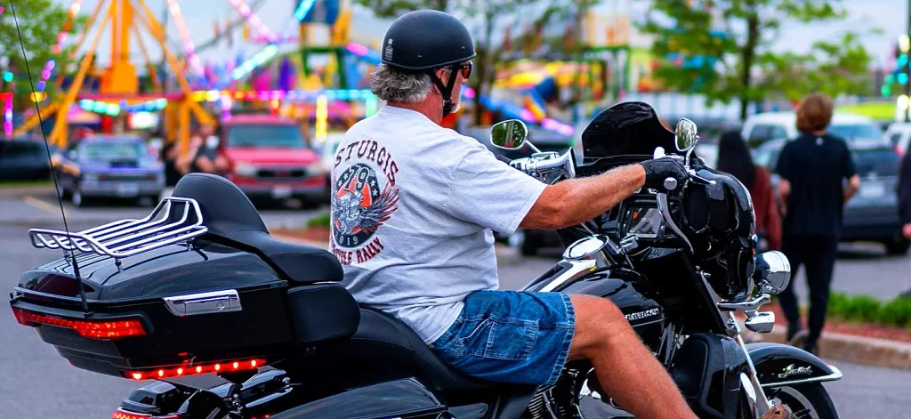 Rider wearing a Sturgis 79th Motorcycle Rally shirt on a black Harley-Davidson at Myrtle Beach Bike Week