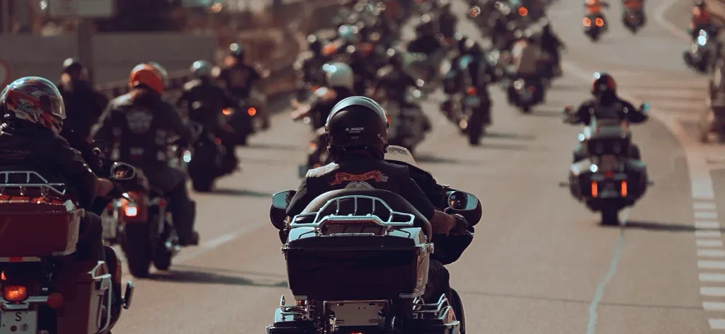Large pack of motorcycles filling a road during Myrtle Beach Bike Week with headlights glowing at dusk