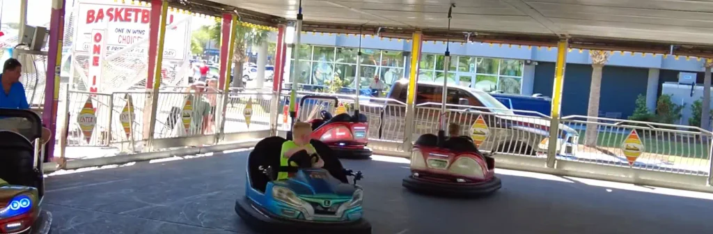 Kids riding bumper cars under a covered pavilion at the Carolina Beach boardwalk