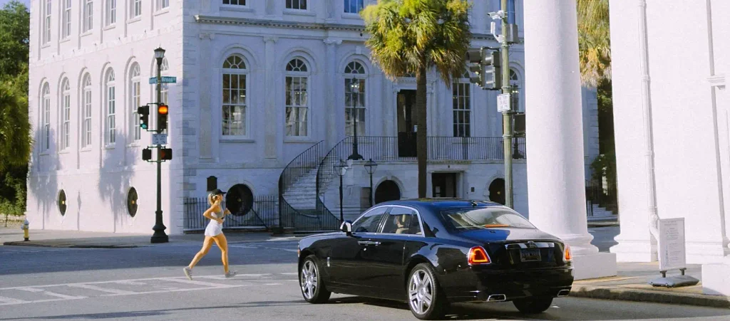 Black car and pedestrian crossing a historic Charleston street