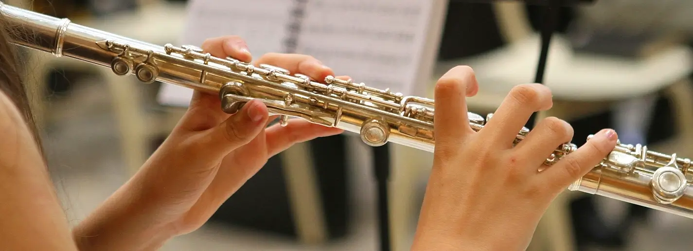 Young musician playing silver flute with sheet music at Lowcountry Jazz Festival