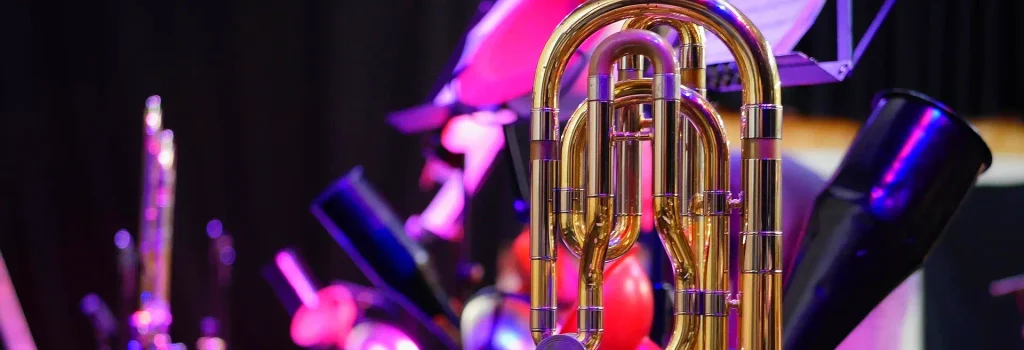Gold trumpet valves glowing under stage lights during a Lowcountry Jazz Festival performance